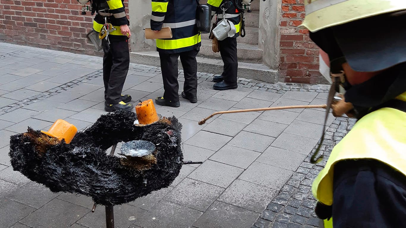 Einsatzkräfte löschen den verbrannten Adventskranz nach: Er ging in Flammen auf.