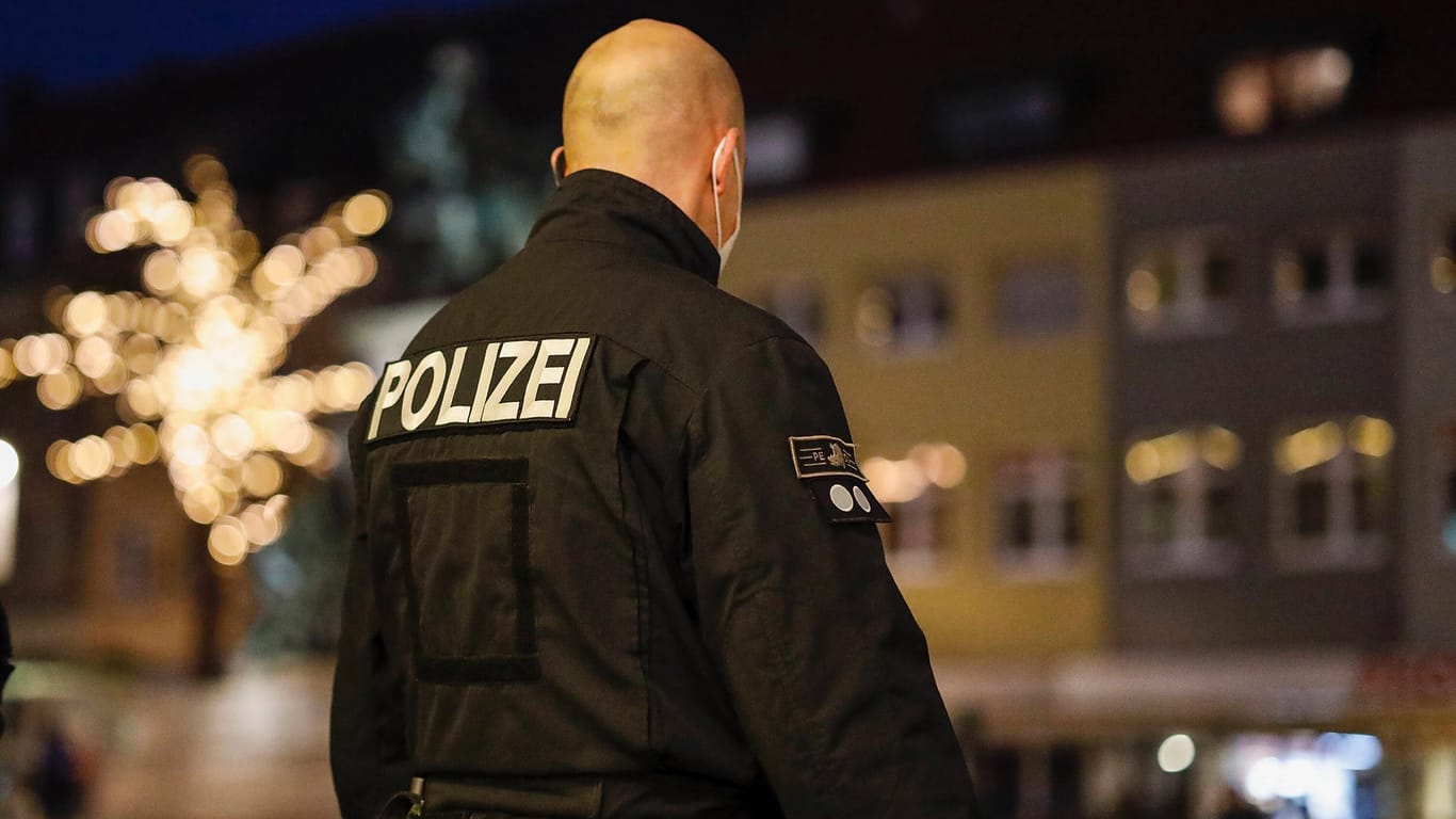 Polizist mit Maske kontrolliert die Ausgangssperre im bayerischen Schweinfurt: In Amberg muss ein Pärchen 1.000 zahlen, weil sie nachts Zigaretten kaufen wollten.