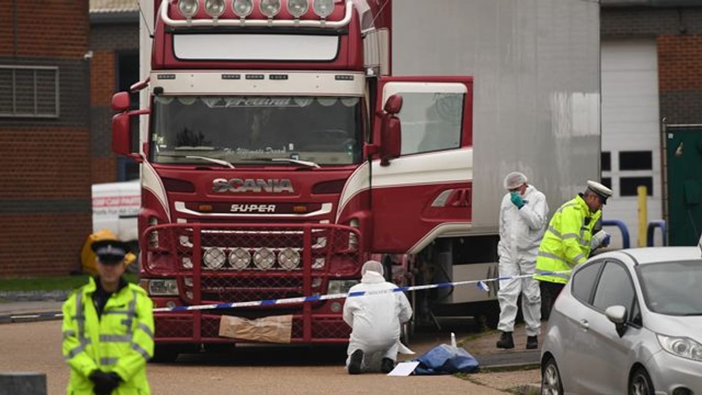 Polizisten und Gerichtsmediziner untersuchen einen Lastwagen, in dem 39 Leichen vietnamesischer Migranten gefunden wurden.