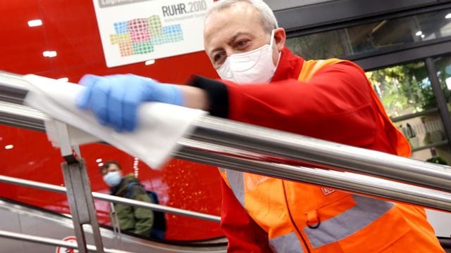 Der Bahnmitarbeiter Yavuz Sanli trägt mit einem weichen Tuch den "Anti-Corona-Lack" auf einen Handlauf im Hauptbahnhof auf (Archivbild): Der Lack soll die Viren abtöten.