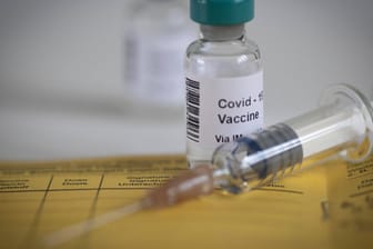 Covid-19-Impfstoff auf einem Impfausweis (Symbolbild): Der Impfstoff soll auch gegen die Coronavirus-Mutation wirksam sein.