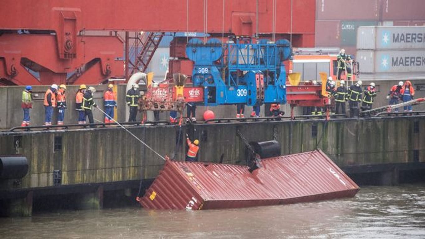 Ein Container schwimmt am Eurogate hinter dem Containerschiff "Delphis Gdansk" im Wasser und wird mit Hilfe eines Krans gesichert: Er war beim Verladen ins Hafenbecken gerutscht.