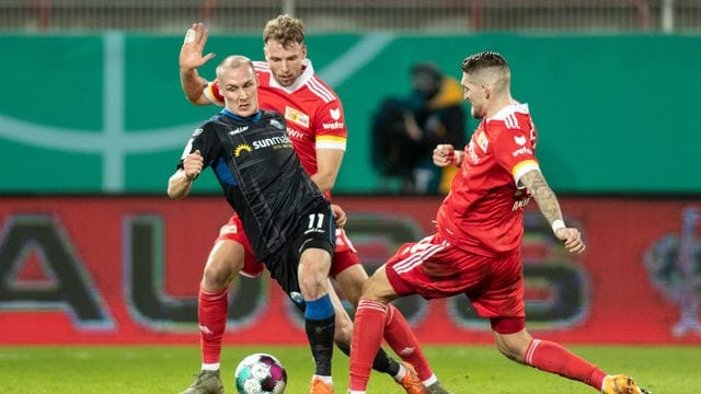 Sven Michel (l-r) vom SC Paderborn kämpft gegen Berlins Marvin Friedrich und Robert Andrich um den Ball.