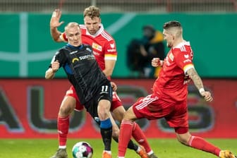 Sven Michel (l-r) vom SC Paderborn kämpft gegen Berlins Marvin Friedrich und Robert Andrich um den Ball.
