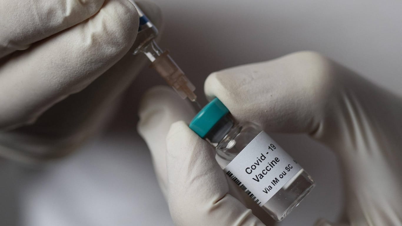 Eine Impfdosis wird in eine Spritze aufgezogen (Symbolbild): In München muss der Impfstart für medizinisches Personal verschoben werden.