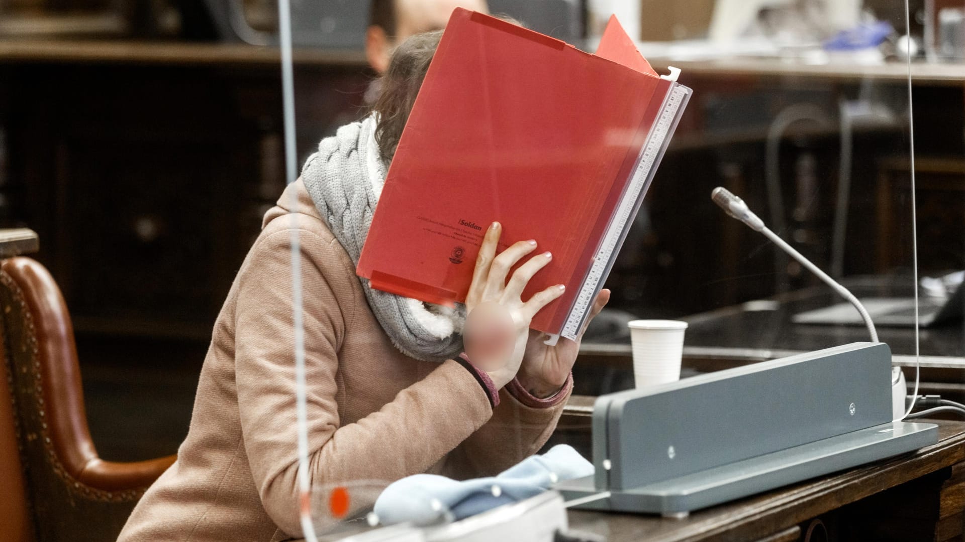Die Angeklagte sitzt im Gerichtssaal und verbirgt ihr Gesicht hinter einem Aktendeckel: Weil sie ihren Lebensgefährten aus Habgier tötete, muss die 37-Jährige eine lebenslange Haftstrafe absitzen. Die Angeklagte sitzt im Gerichtssaal und verbirgt ihr Gesicht hinter einem Aktendeckel: Weil sie ihren Lebensgefährten aus Habgier tötete, muss die 37-Jährige eine lebenslange Haftstrafe absitzen.