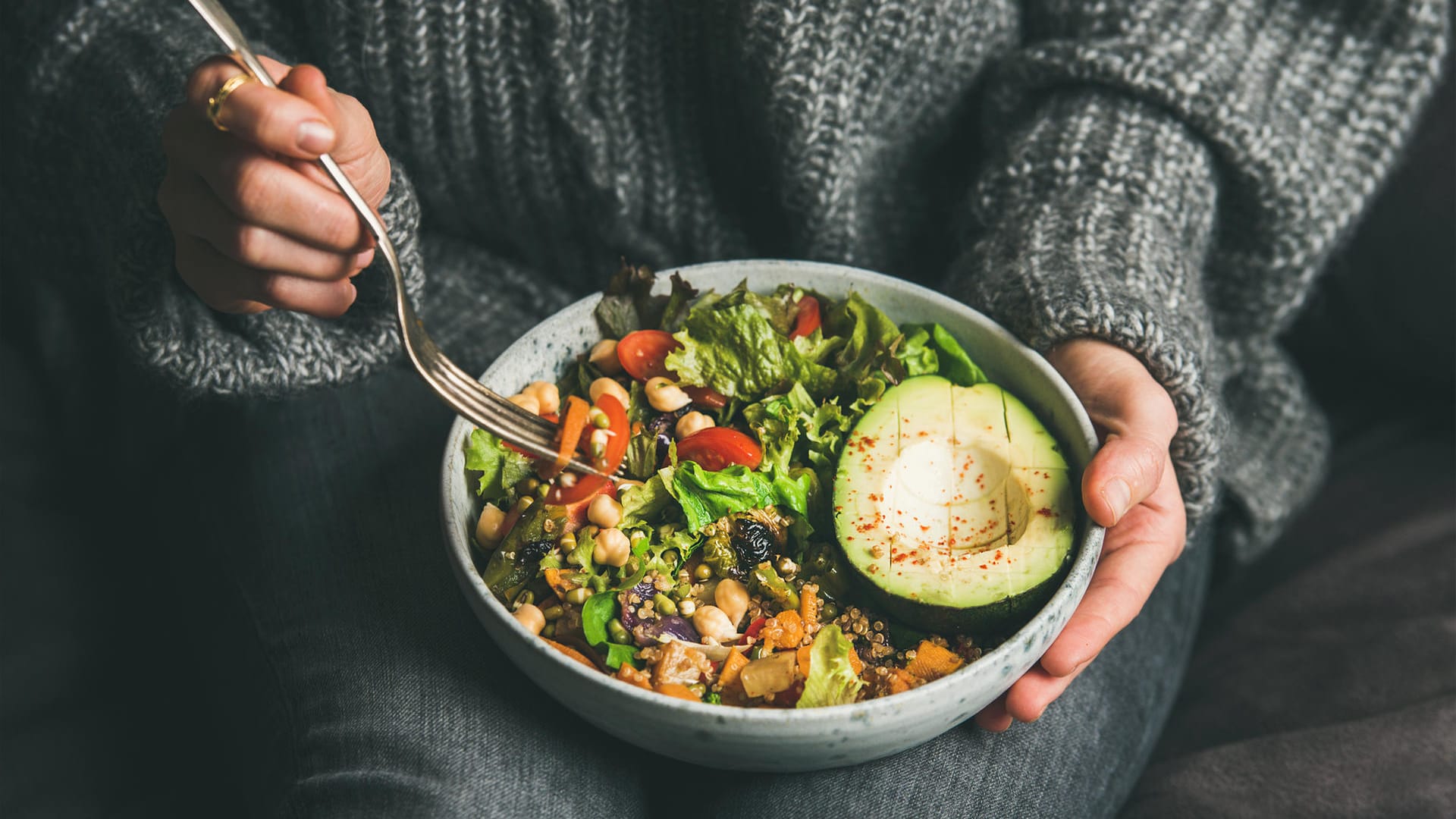 Eine Frau isst eine vegetarische "Buddha-Bowl". Wer sich vitiamin- und ballaststoffreich ernährt, kommt besser durch den Lockdown.