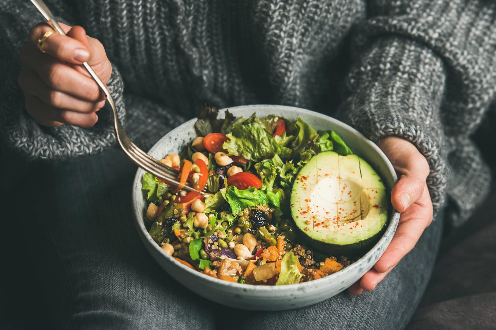 Eine Frau isst eine vegetarische "Buddha-Bowl". Wer sich vitiamin- und ballaststoffreich ernährt, kommt besser durch den Lockdown.