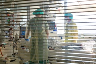 Intensivpfleger stehen an einem Krankenbett (Symbolbild): Weil die bisherigen Kapazitäten erschöpft sind, richtet das Klinikum Karlsruhe eine weitere Covid-Station ein.