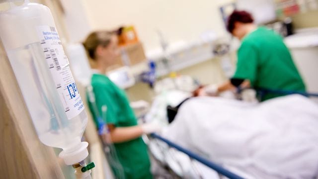 Medizinisches Personal versorgt in einem Krankenhaus einen Patienten.