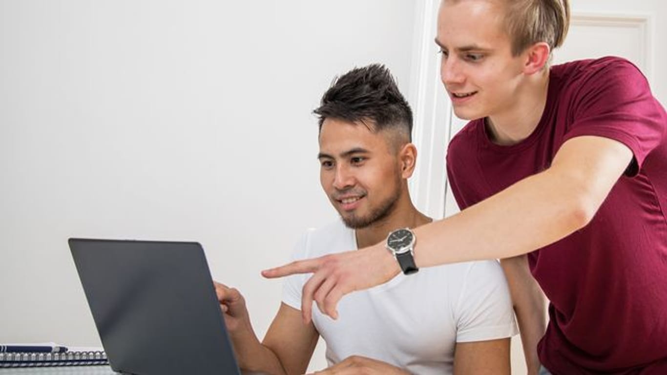 Zwei junge Menschen am Laptop: Wer im Internet nach Schnäppchen sucht, sollte ein paar Dinge beachten.
