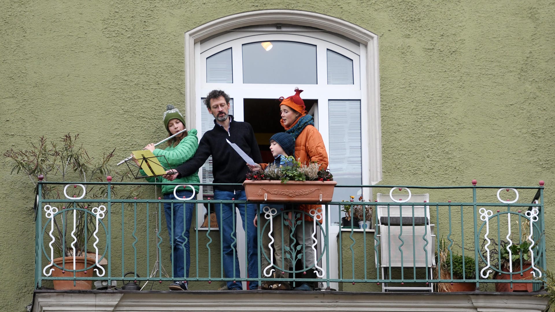 Eine Familie singt auf dem Balkon ihrer Wohnung: Zwischenzeitlich wurden die Musikanten vom Glockengeläut der Kirchen übertönt.