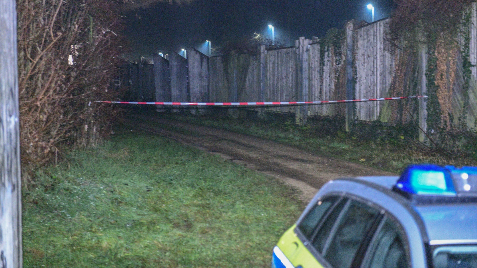 Ein Polizeiwagen steht vor einer Absperrung: Der Getötete soll laut Zeugenaussagen von maskierten Männern angegriffen worden sein.