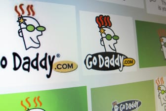 Logos der Internetfirma GoDaddy auf einem Bildschirm: Die US-Firma hat ihren Mitarbeitern eine fiese Phishing-Mail geschickt.