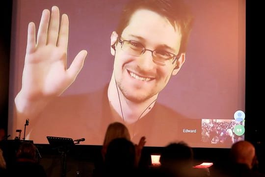 Der NSA-Enthüller Edward Snowden winkt während einer Videoschalte dem Publikum zu.