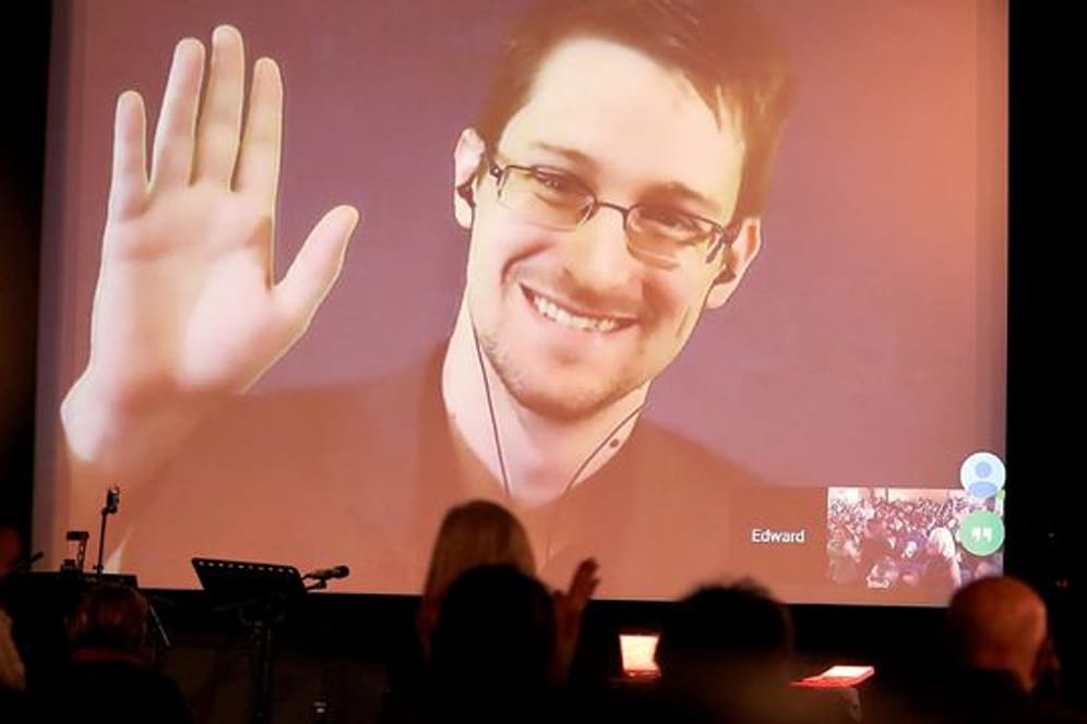 Der NSA-Enthüller Edward Snowden winkt während einer Videoschalte dem Publikum zu.