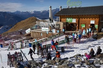 Skifahrer stehen auf einer Piste im Walliser Skigebiet vor einem Restaurant Schlange (Archivbild vom 28.