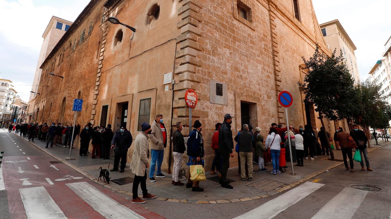 Menschen vor einer Essensausgabe in Palma: Seit Beginn der Corona-Krise richten sich weit mehr Menschen an die wohltätigen Einrichtungen auf Mallorca.