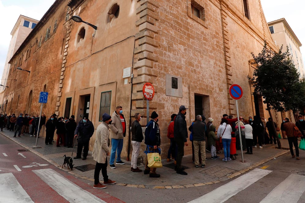 Menschen vor einer Essensausgabe in Palma: Seit Beginn der Corona-Krise richten sich weit mehr Menschen an die wohltätigen Einrichtungen auf Mallorca.