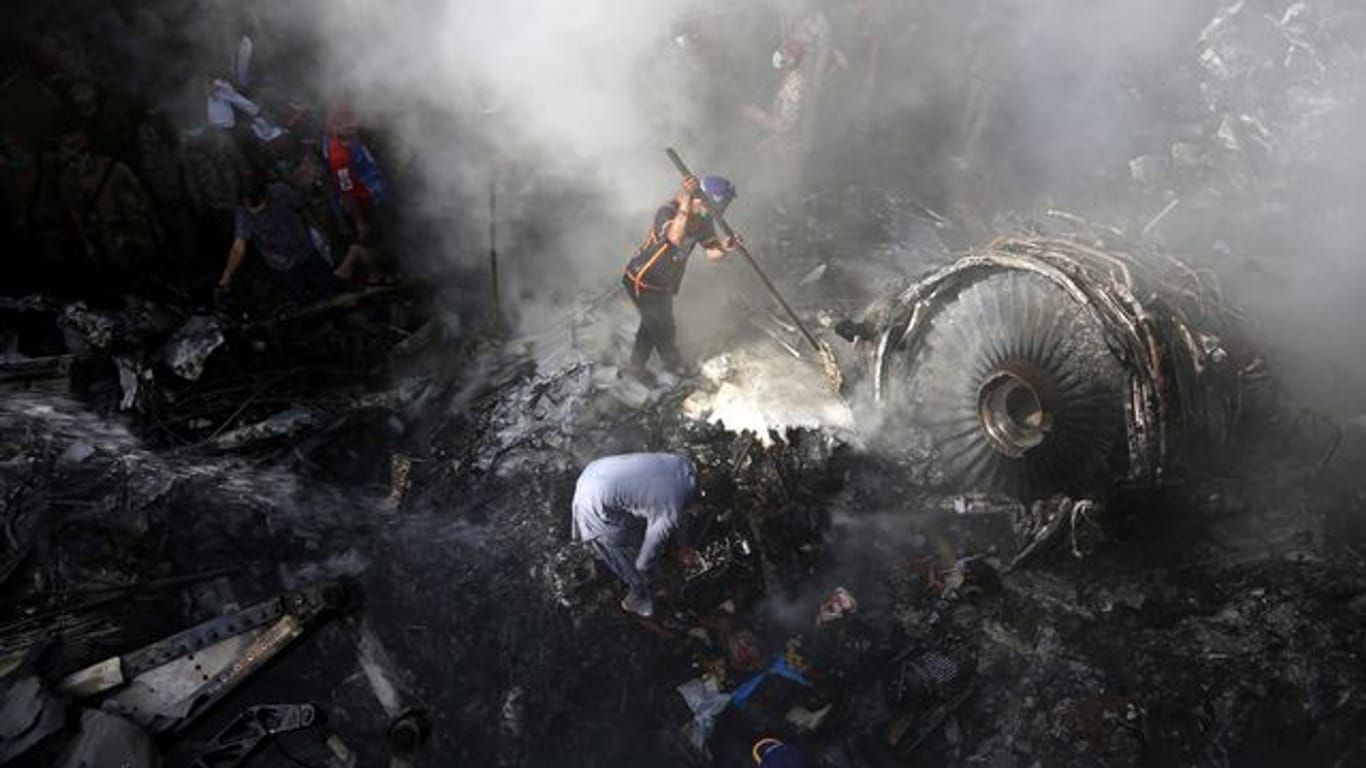 Helfer und Einsatzkräfte suchen nach dem Absturz einer Maschine der Fluggesellschaft Pakistan International Airlines (PIA) in Karatchi nach Überlebenden.