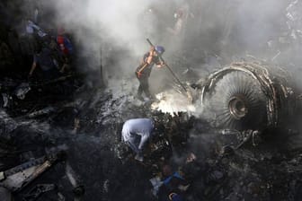 Helfer und Einsatzkräfte suchen nach dem Absturz einer Maschine der Fluggesellschaft Pakistan International Airlines (PIA) in Karatchi nach Überlebenden.