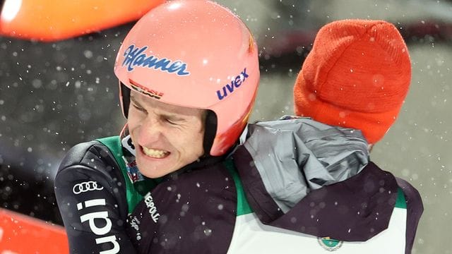 Sieger Karl Geiger umarmt nach dem entscheidenden Sprung Kumpel Markus Eisenbichler.