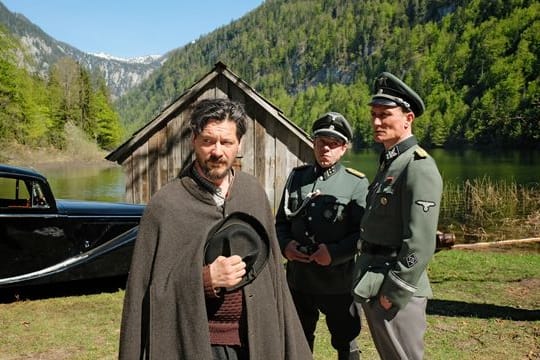 Sepp Rottenbacher (l, Fritz Karl) muss Kaltenbrunner (r, Oliver Masucci) und Schädler (M, George Lenz) auf den See rudern.