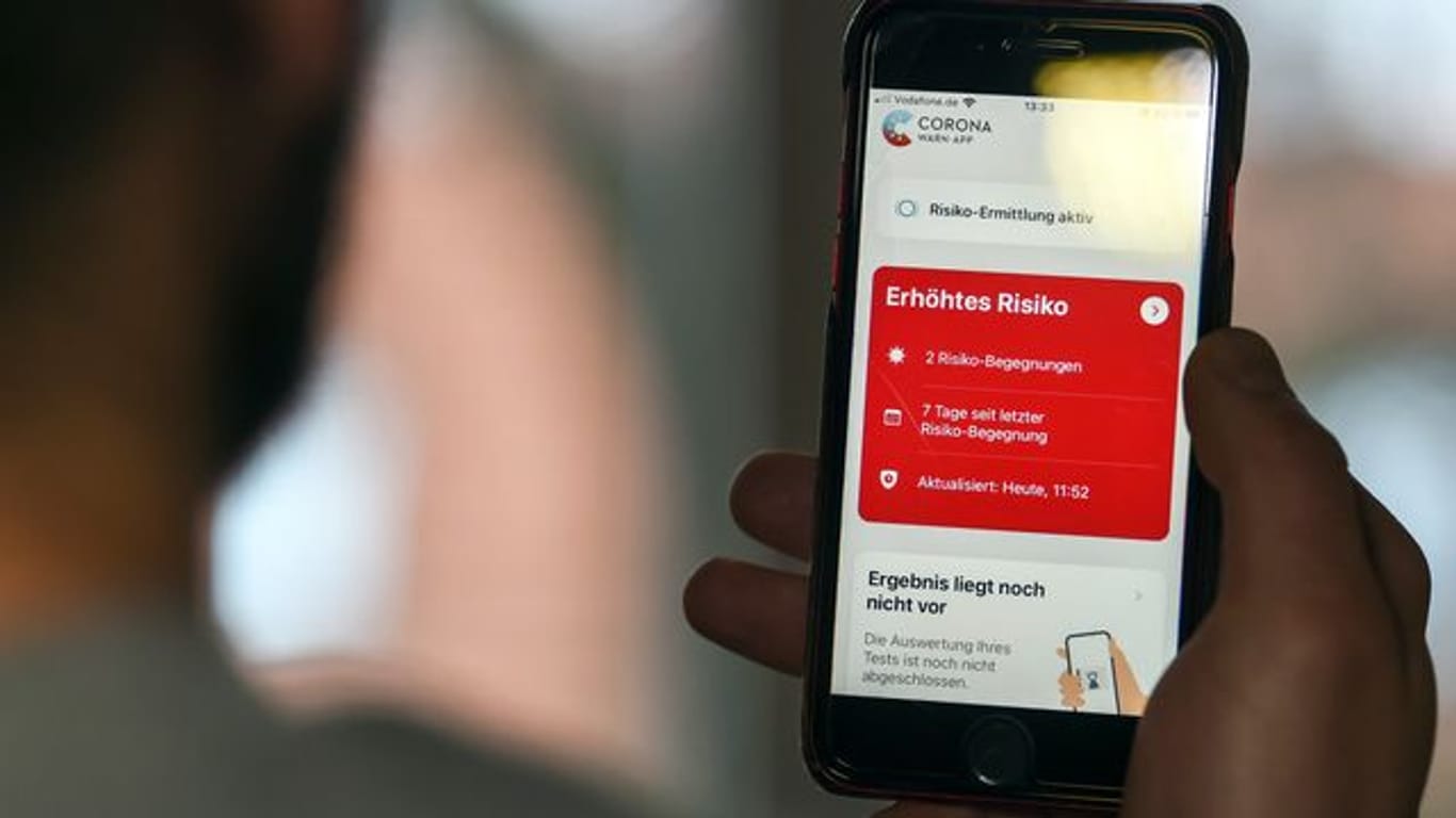 Auf einem Handy zeigt die "Corona Warn-App" ein erhöhtes Risiko an, welches darauf hinweist Kontakt mit einer infizierten Person gehabt zu haben.