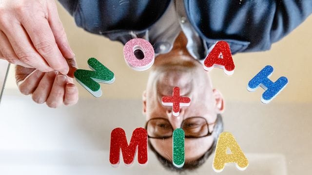 Der Vornamen-Experte Knud Bielefeld legt mit Buchstaben die beliebtesten Vornamen des Jahres 2020, Mia und Noah, auf einem Spiegel. Der Vornamen-Experte Knud Bielefeld legt mit Buchstaben die beliebtesten Vornamen des Jahres 2020, Mia und Noah, auf einem Spiegel.
