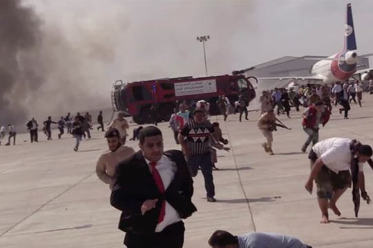 Menschen rennen nach einer schweren Explosion fluchtartig über den Flughafen der jemenitischen Stadt Aden.