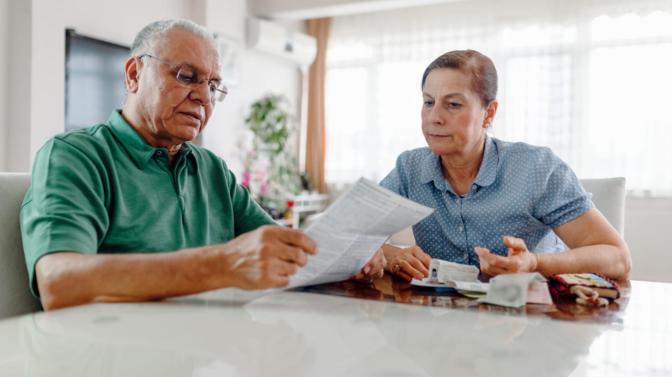 Ein älteres Paar sieht Rechnungen durch (Symbolbild): Wenn die private Krankenversicherung im Alter immer teurer wird, kann das zum Problem werden.