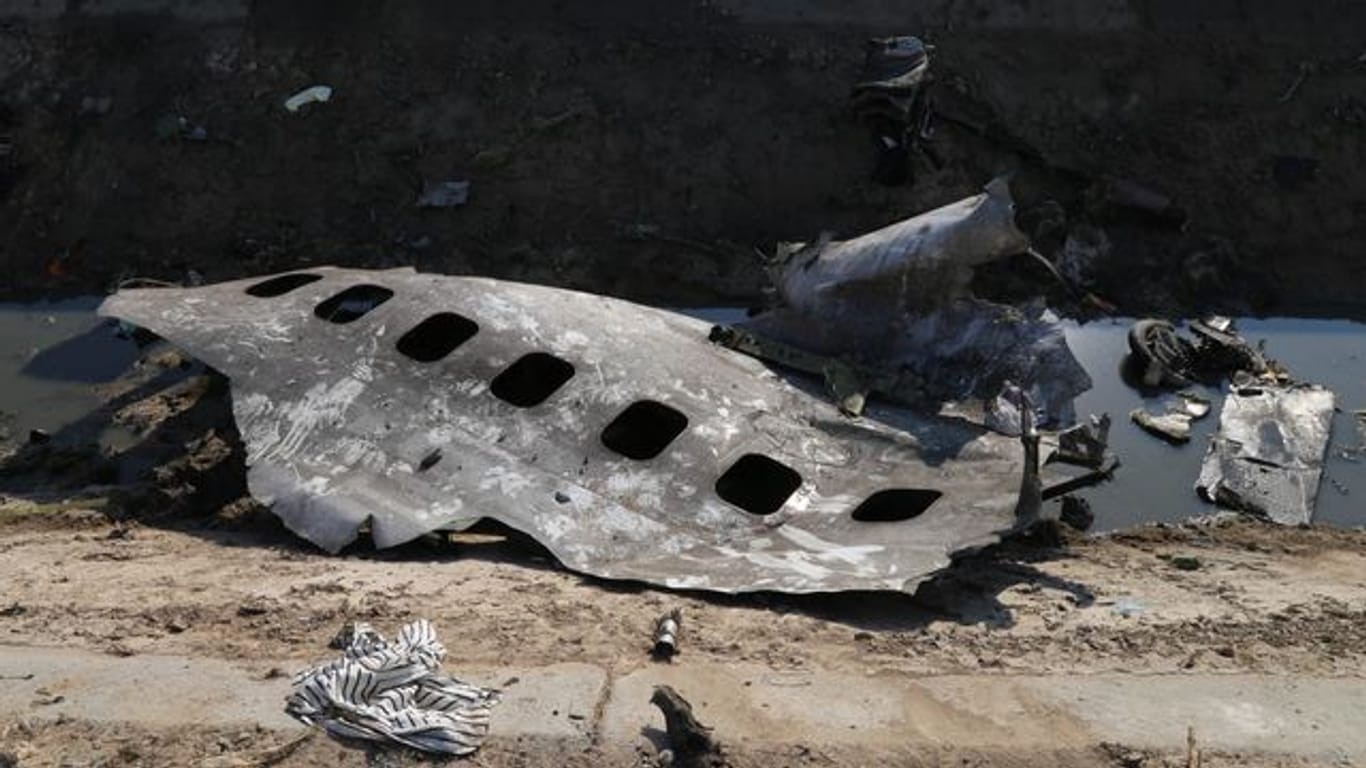 Trümmerteile der ukrainischen Passagiermaschine liegen am Absturzort.