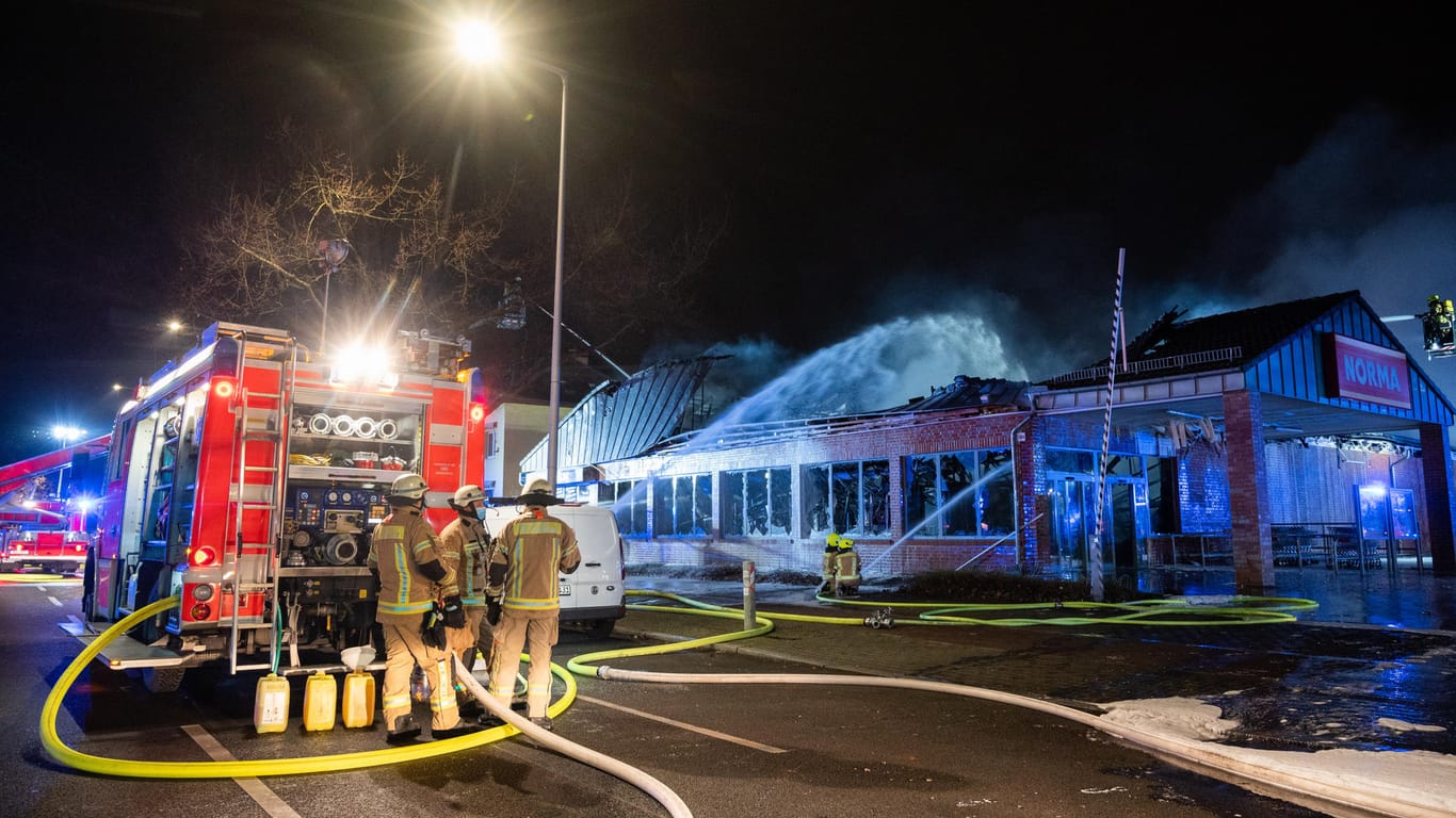 Feuerwehrleute löschen einen brennenden Supermarkt: In Berlin ist eine Discounter-Filiale abgebrannt.