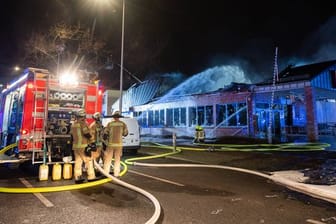 Feuerwehrleute löschen einen brennenden Supermarkt in Berlin.