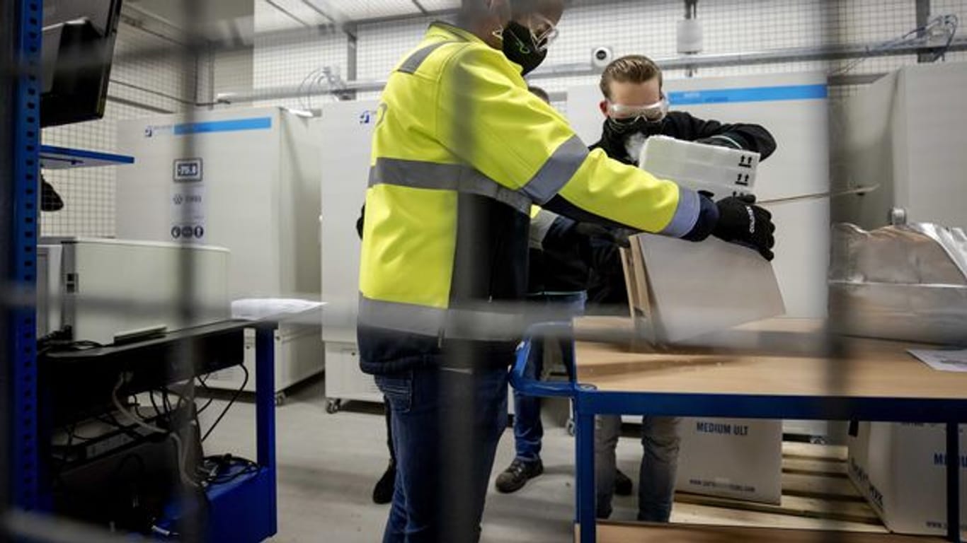 Mitarbeiter packen den ersten Corona-Impfstoffe von Pfizer und Biontech für die Niederlande aus.