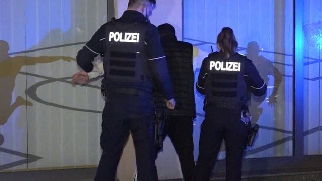 Einsatzkräfte der Polizei kontrollieren einen Mann