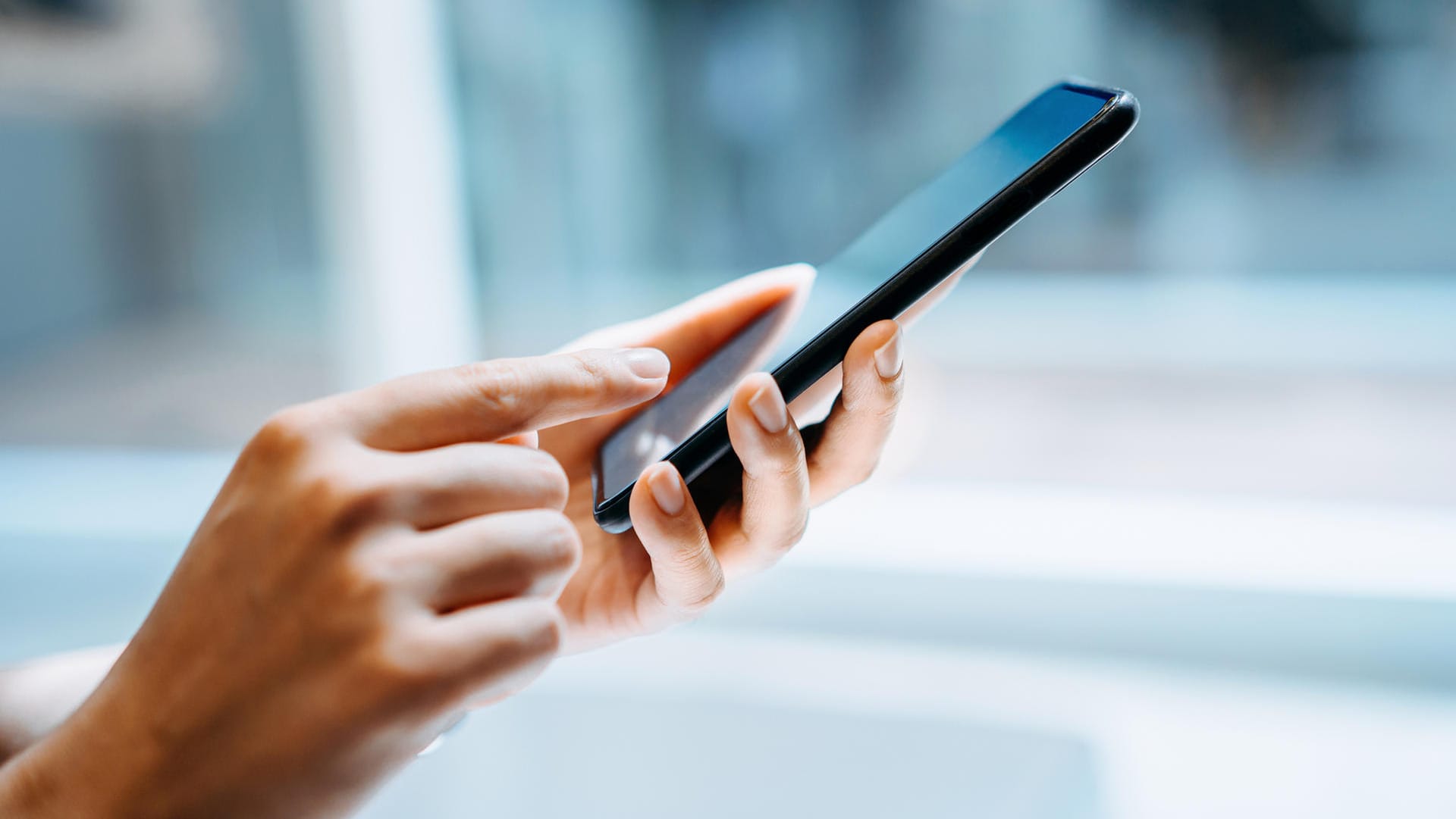 Eine Frau hält ein Smartphone (Symbolbild): Die CSU wünscht sich einen digitalen Personalausweis.