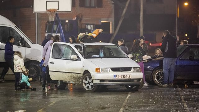 Menschen stehen neben Fahrzeugen, während sie aus Angst vor Nachbeben die Nacht im Freien verbringen. Menschen stehen neben Fahrzeugen, während sie aus Angst vor Nachbeben die Nacht im Freien verbringen.