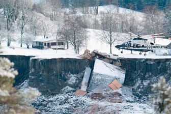 Ask in Norwegen: Ein Helikopter fliegt über die Stelle, an der ein Erdrutsch zahlreiche Häuser in die Tiefe gerissen oder zerstört hat.