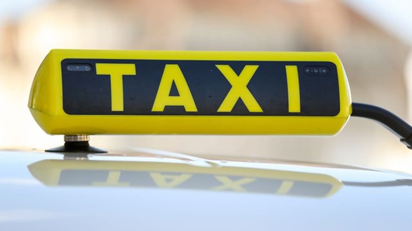 Ein Taxischild an einem Taxi (Symbolbild): Berliner über 90 können kostenlos mit dem Taxi zum Impfzentrum fahren.