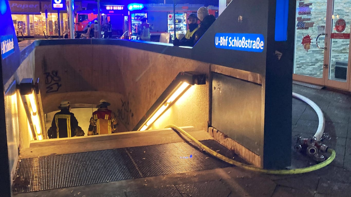 Feuerwehrleute gehen an der Schloßstraße in Steglitz in einen Eingang der U-Bahn: Dort hatte es gebrannt, weswegen der Verkehr unterbrochen werden musste.