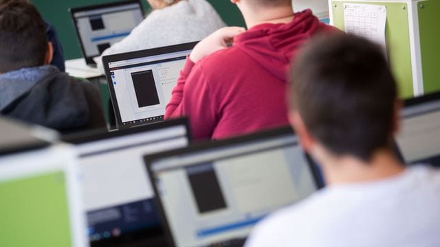 Schüler und Schülerinnen mit Laptops im Unterricht. Schüler und Schülerinnen mit Laptops im Unterricht.