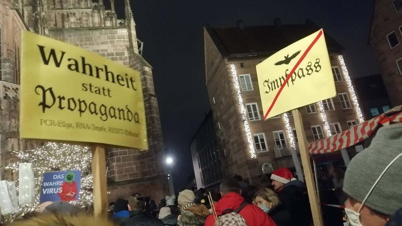 Schilder werden auf der Corona-Demo in Nürnberg gehalten: Hunderte versammelten sich vor der Frauenkirche.