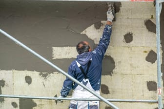 Arbeiter verputzt die Fassade eines Neubaus (Symbolbild): Im Baugewerbe nahm die Zahl der Erwerbstätigen entgegen des allgemeinen Trends zu.