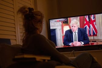 Eine Frau verfolgt im Fernsehen die Ansprache von Premierminister Boris Johnson an die Nation.
