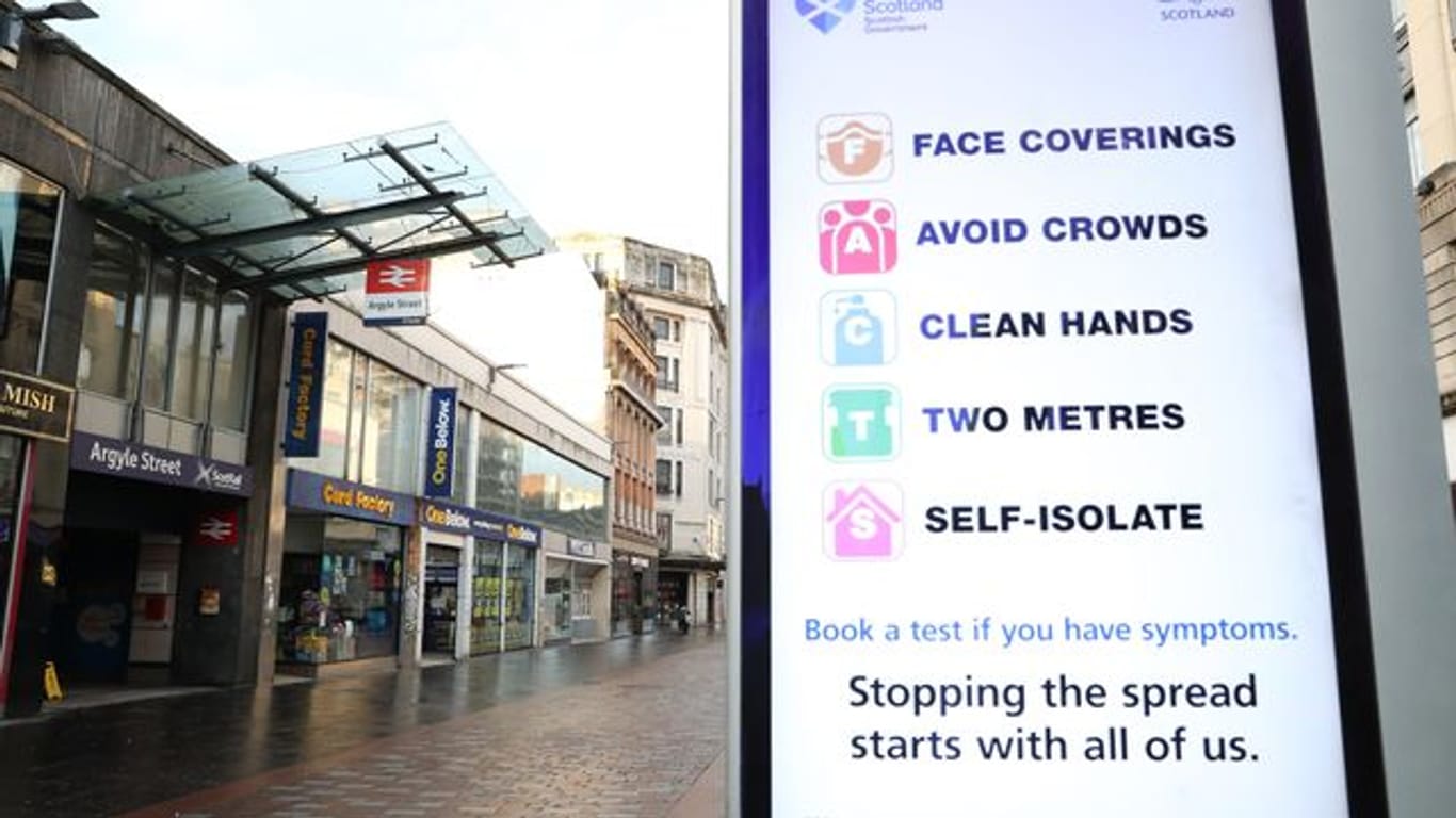 Ein Schild vor der Station Argyle Street im Stadtzentrum von Glasgow weist auf Abstands- und Hygieneregeln hin.