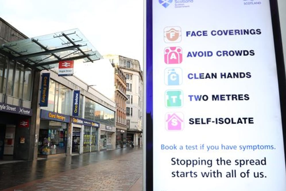 Ein Schild vor der Station Argyle Street im Stadtzentrum von Glasgow weist auf Abstands- und Hygieneregeln hin.