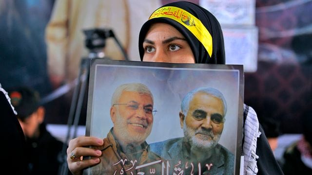 Eine Frau hält ein Bild des einflussreichen irakischen Milizen-Anführers Abu Mahdi al-Muhandis (l) und des iranischen Top-Generals Ghassem Soleimani, die am 03. Eine Frau hält ein Bild des einflussreichen irakischen Milizen-Anführers Abu Mahdi al-Muhandis (l) und des iranischen Top-Generals Ghassem Soleimani, die am 03.