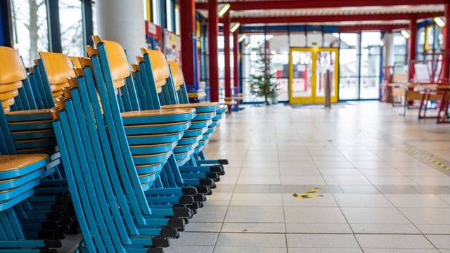 Gestapelte Stühle stehen im Eingangsbereich einer Realschule.