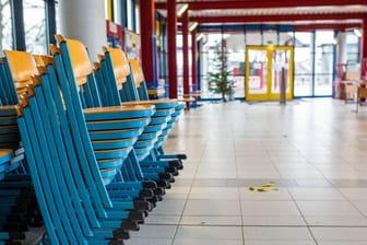 Gestapelte Stühle stehen im Eingangsbereich einer Realschule.